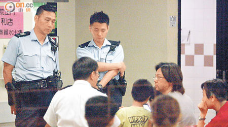 疑被打傷男童在醫院驗傷，其父（右）接受警員調查。