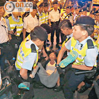 警方凌晨時分開始清場，將坐在馬路的示威者抬走。（陳章存攝）