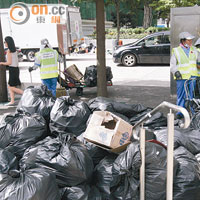 佔中預演過後，中環港鐵站外遺下大量示威用品及垃圾，後被清潔人員包好。