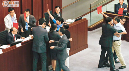 多名泛民議員衝到吳亮星面前高舉紅牌，以示要求吳辭去主席職務。（黃永俊攝）