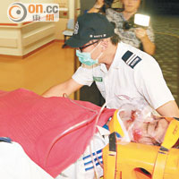 重傷青年由救護員送院救治。（麥少峰攝）