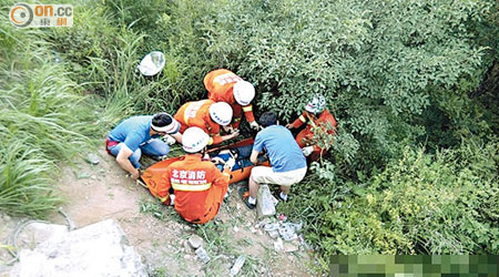 搶救人員在女遊客墮山位置即場急救。