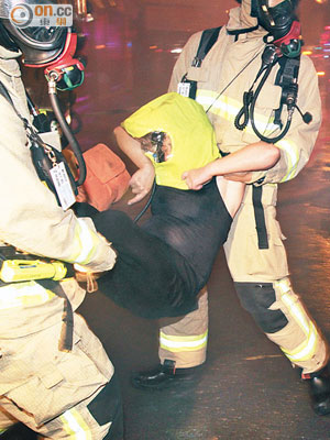 消防員合力將醉婦救離大廈及送院。（胡德威攝）