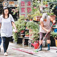 雨後路面遺留油污，商戶忙於清理。