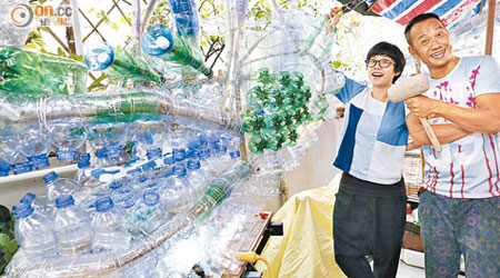 彭金有（右）及Kitty用三百多個水樽製成綠色藝術龍，冀大眾反思環保議題。（何頴賢攝）