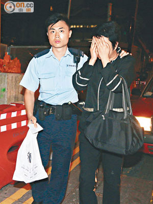 涉嫌偷酒女侍應被拘捕，警員檢走酒樽等證物。（沈厚錚攝）