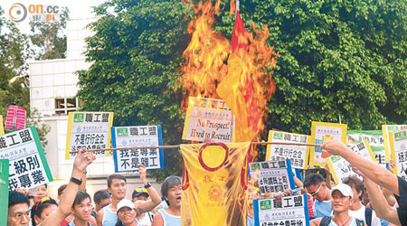 救生員焚燒寫上「技工」兩字的救生衣，以示不滿。（蕭毅攝）