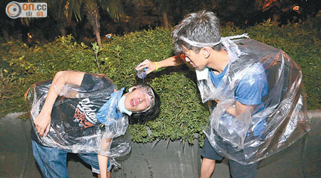 佔中示威者守望相助，用水洗眼。