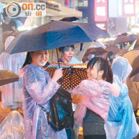 參與集會的市民出盡雨傘及雨衣應付雷雨。（陳章存攝）