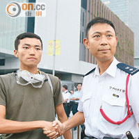 楊姓大學生（左）留守特首辦四天，昨日黃昏與警方握手宣布「交場」。