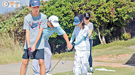 無懼酷熱烈日，同學在教練指導下學習高爾夫球。