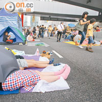 部分留守市民席地而睡，雨傘回歸遮擋太陽的基本功能。