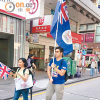 有市民在旺角街頭揮舞港英龍獅旗和英國國旗。