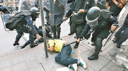 ○八年曼谷示威，示威者倒地後仍被防暴警察以警棍狠打。