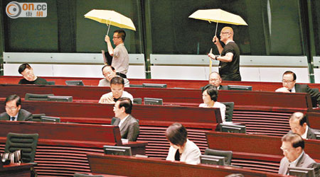 人力議員陳志全（左）及陳偉業（右）在開會前打黃傘抗議。