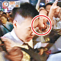 警員護送電視台記者離開期間，再有示威者向該記者揮拳襲擊（圓圈示）。