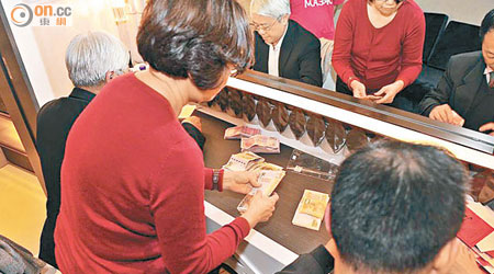 密件附有多幅相信在朱耀明壽宴上拍攝的照片，顯示有人正在點算一疊疊現鈔。