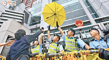 梁國雄將黃色雨傘掟入中聯辦，要求內地釋放所有在囚政治犯。