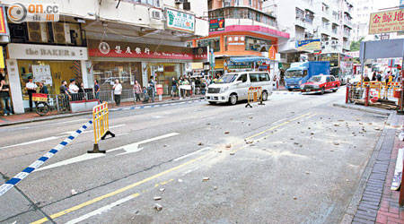 數十塊碎石散滿地上，警方將一段行車線及小巴站封鎖。