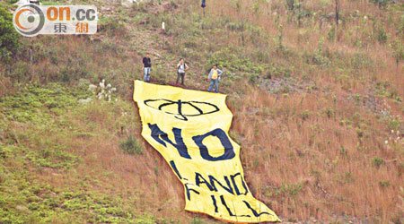 五名打鼓嶺村民將寫上「NO LANDFILL」的黃色巨型標語掛起。