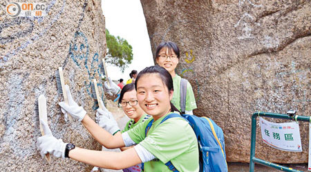 青少年參賽者協助洗刷長洲五行石附近的塗鴉，身體力行保護地貌。