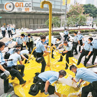 一批警員徒手把大型雨傘拆除。