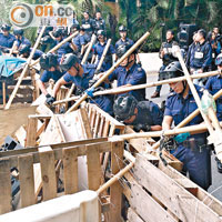 警員拆除用木卡板構建的路障。