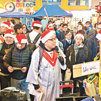 銅鑼灣<br>「快必」（持咪者）稱到銅鑼灣報佳音，與身穿聖誕老人裝的張牧師帶領「報佳音鳩嗚團」。