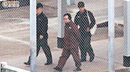 身穿囚服的郭炳江在兩名懲教署人員監管下，拖着沉重腳步，前往會見子女。（袁志豪攝）