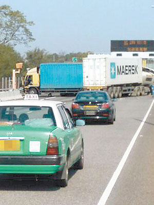 其中兩部貨櫃車橫亘路中。（讀者提供圖片）