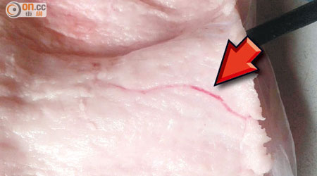 豬肉內出現幼長紅線，疑似是寄生蟲（箭嘴示）。