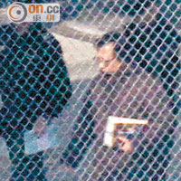 郭炳江昨在懲教人員監管下，手持一本書回囚室。