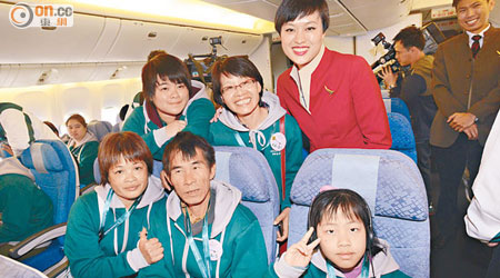 正姑（前排左一）一家與空姐合照，場面熱鬧。（蕭毅攝）