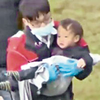 機上一名小童奇迹生還，由救援人員抱走。（互聯網圖片）