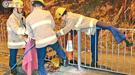 消防員剪開鐵欄拯救。（麥少峰攝）