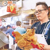 牛池灣街市雞販兼港九雞鴨行職業公會副主席馬平龍，昨日購入卅隻文昌雞出售。（鄧宇航攝）