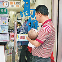 內地遊客馬生抱着發燒兒子，在荃灣一診所外等候逾三小時。