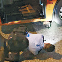 男途人被困車底，警員探看其情況及傷勢。（互聯網圖片）