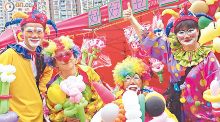 嚴蘭英（左二）修畢課程後，與人合資逾二萬六千元，投得年宵巿場乾貨攤檔，出售卡通人物氣球。