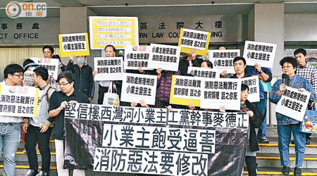十三名被票控的堅信樓業主，連同區內其他舊樓業主，在庭外抗議。