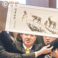 范國威高舉「臨崖推狼」水墨畫示威。