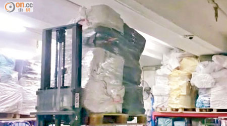 本報取得相片顯示，郵政外判商貨倉內，有人疑為騰出更多空間，用電動唧車把郵包擠壓至天花。