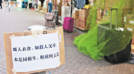 有店舖在門外貼上反示威標語，批評反水貨示威者「斷人衣食」。（朱先儒攝）