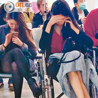 受傷女乘客坐在輪椅上等候治療，旁為另一女乘客。 （冼耀華攝）