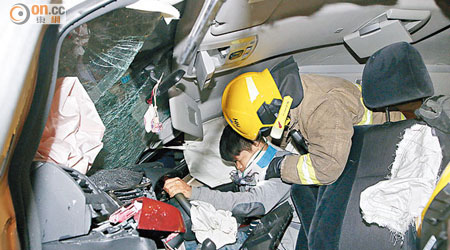 消防員拯救被困的七人車司機。（沈厚錚攝）