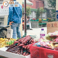 被列為法定古蹟的文武廟門前有小販擺賣糖果及臘肉等貨品。