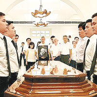 李光耀遺體放入棺木，兩旁站立者為生前保護他的護衞人員。（新加坡政府圖片）