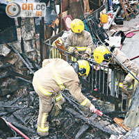 木屋燒成廢墟，消防員在場調查。（梁卓明攝）