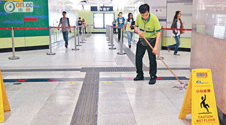 香港大學站 <br>西港島線香港大學站內因滲水問題積水處處，工人忙於清理。