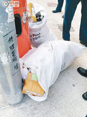 有市民發現秦石邨旁巴士站附近，有大型郵袋被棄置在垃圾桶旁。（讀者郵棍提供）